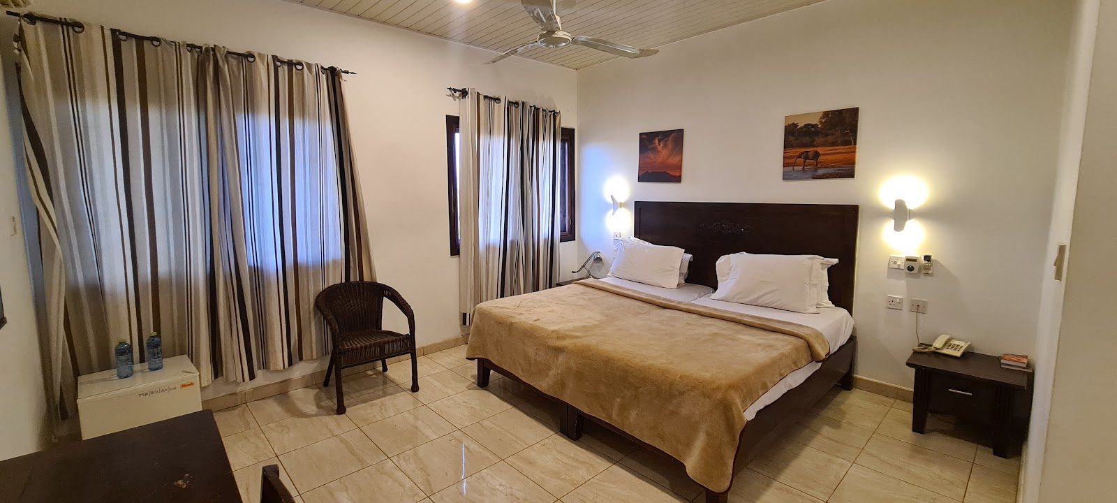 Spacious guest room with double bed, desk and ceiling fan