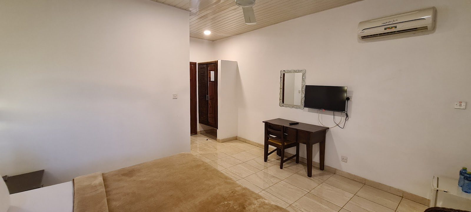 Guest room showing television, desk and air conditioner